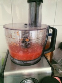 de gepelde tomaten toevoegen aan de groentes en goed fijnsnijden tot het een puree is geworden
